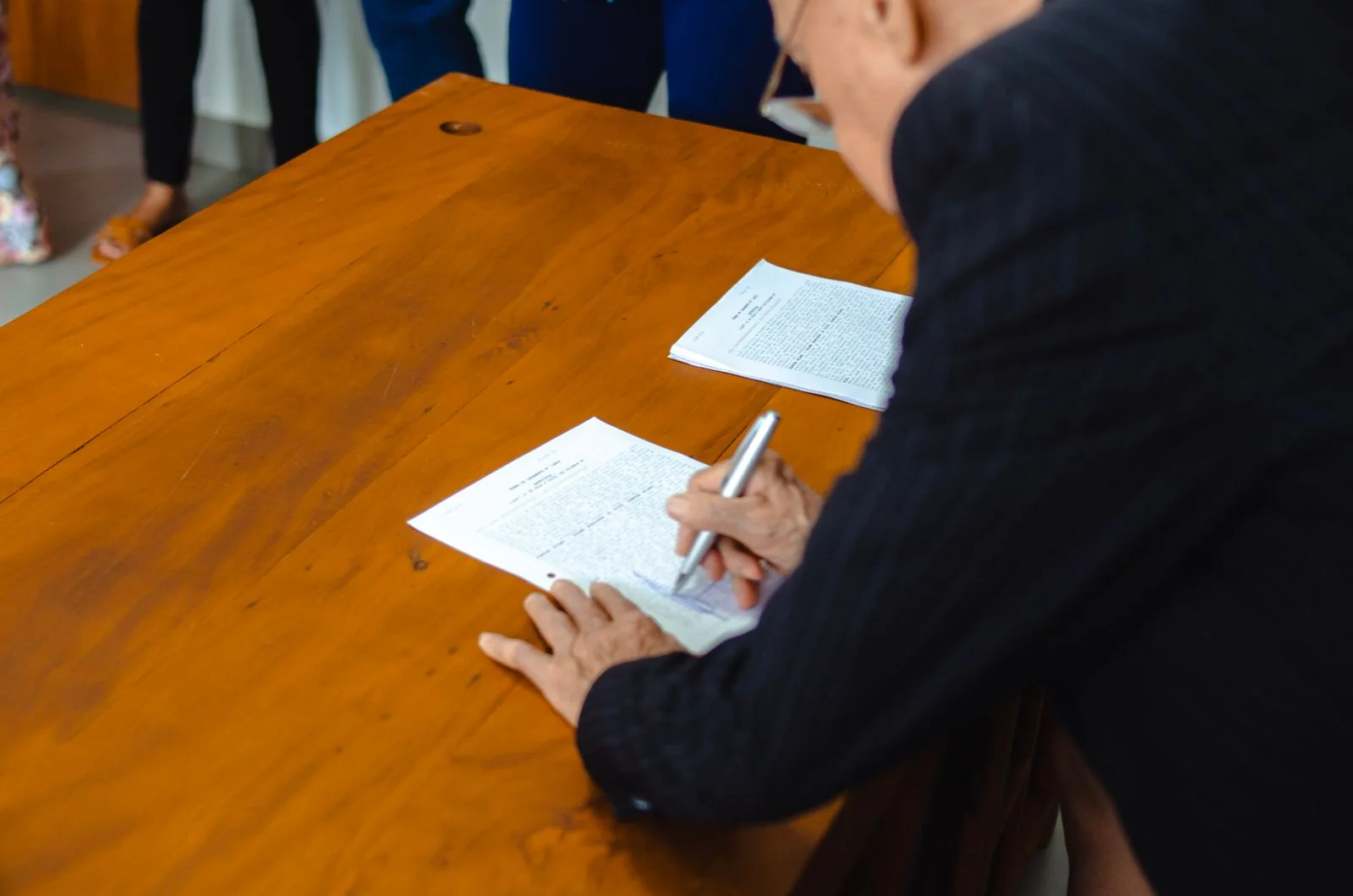 Person filling a document at a desk