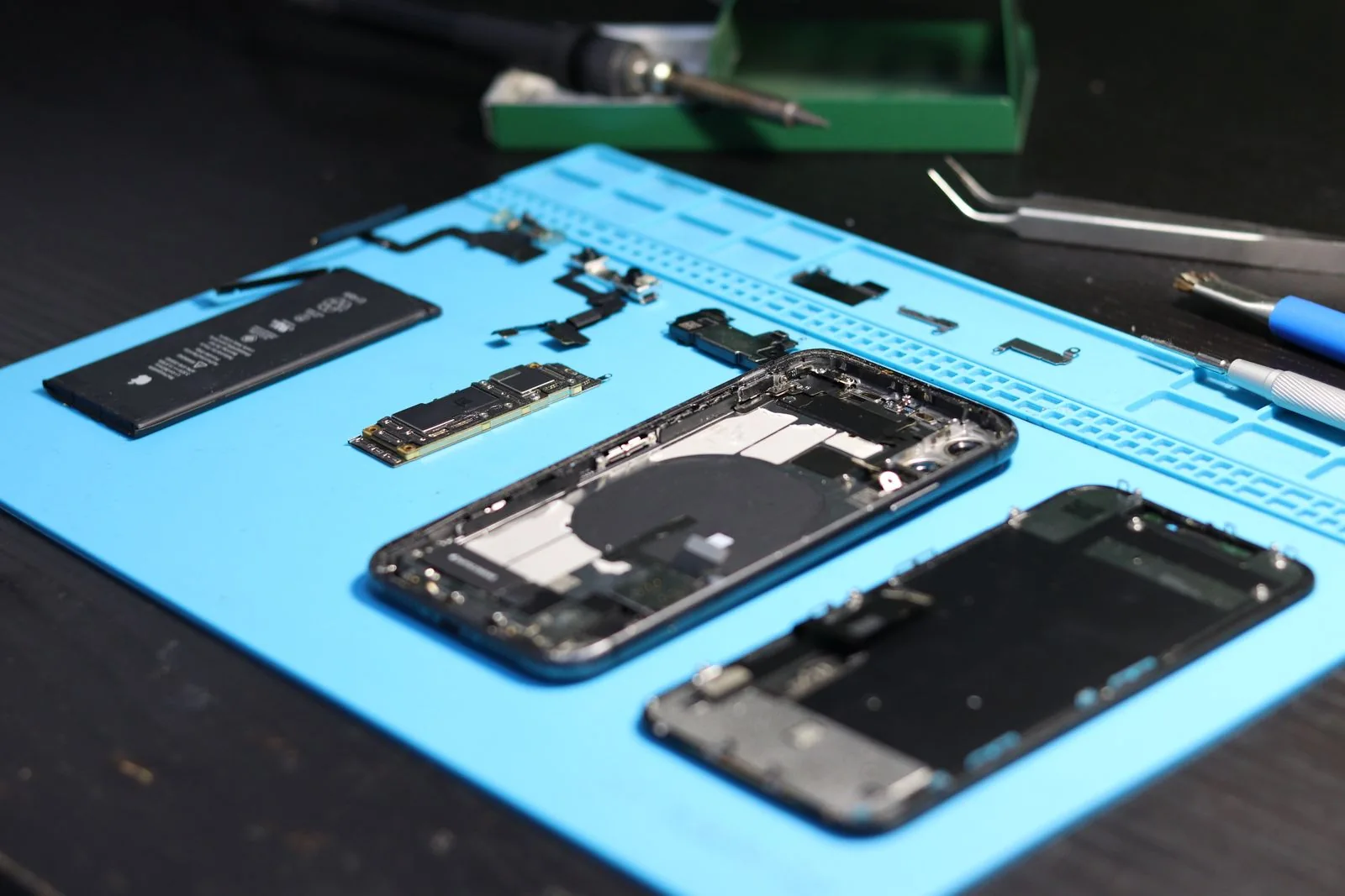 Technician working on a disassembled smartphone