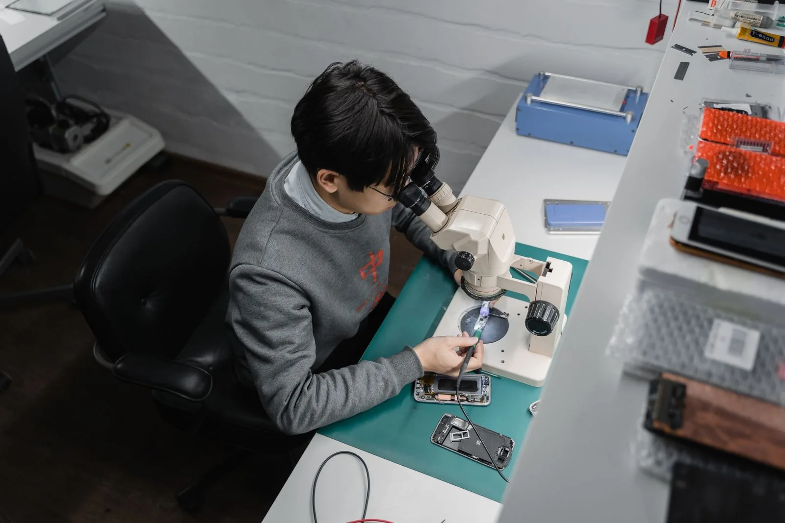 Technician working at a mobile phone repair bench
